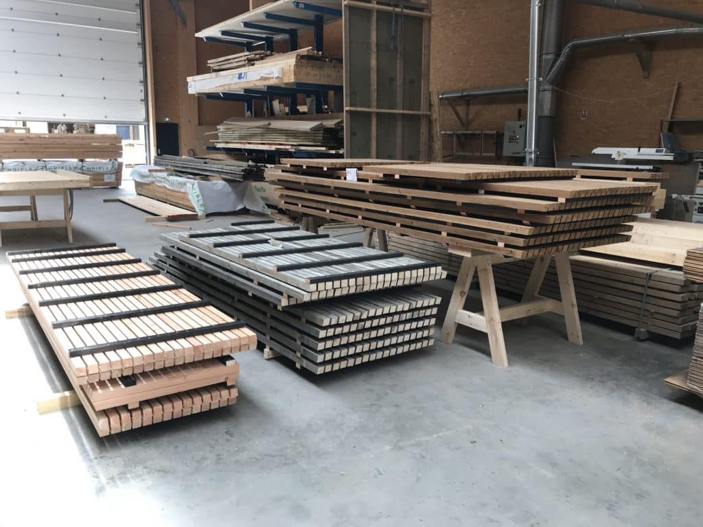 Poteau pin sylvestre fraichement coupe — sortie machine CNC atelier