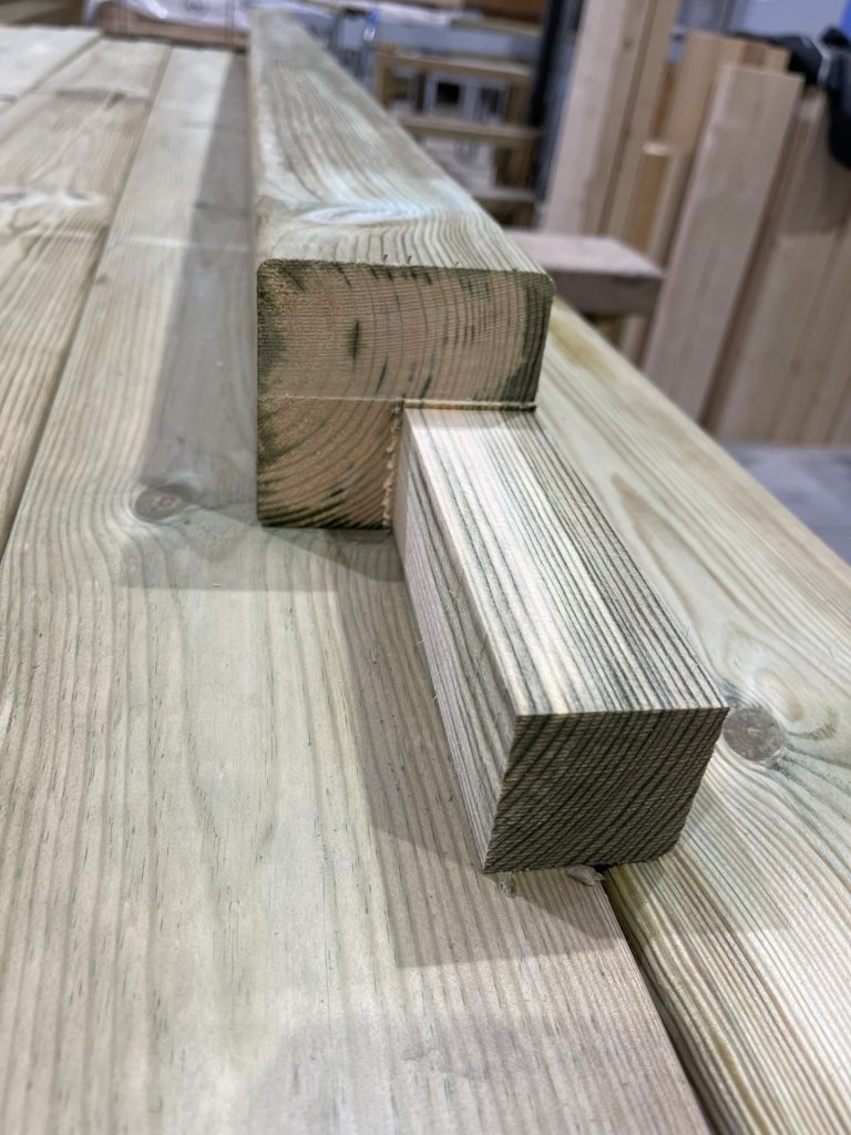 Tiny-house en construction dans atelier — bardage tasseaux pose, equipe au travail